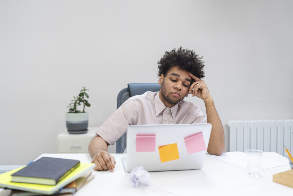 A man feeling stressed at a laptop showing how to stay mentally strong in difficult times