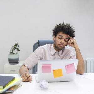 A man feeling stressed at a laptop showing how to stay mentally strong in difficult times