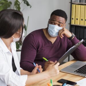 Medical consultation with face masks discussing preventive healthcare tips, wellness planning, and patient guidance.