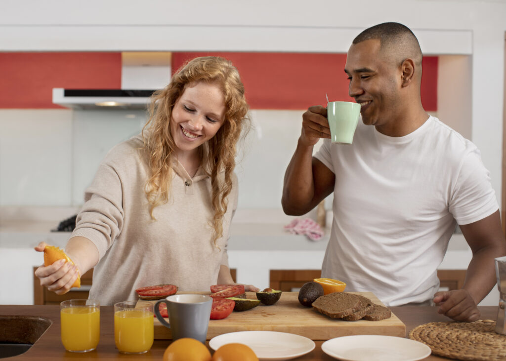 A couple in a kitchen preparing one of 10 healthy breakfast ideas with fruits, avocado, and whole-grain bread.