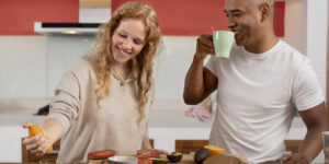 A couple in a kitchen preparing one of 10 healthy breakfast ideas with fruits, avocado, and whole-grain bread.