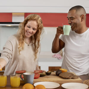 A couple in a kitchen preparing one of 10 healthy breakfast ideas with fruits, avocado, and whole-grain bread.