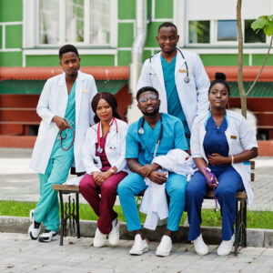 African healthcare students sitting outdoors discussing the best free health scholarships for international students.